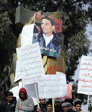 متظاهرون تجمعوا حول صورة لمحمد البوعزيزي في سيدي بوزيد في 0 كانون الثاني/يناير 2011 (ارشيف اف ب, فريد دوفور)